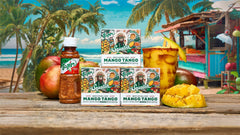 Three Squatch Mango Tango natural soap bars with sea salt and lime peel powder displayed on wooden surface with tropical beach background.